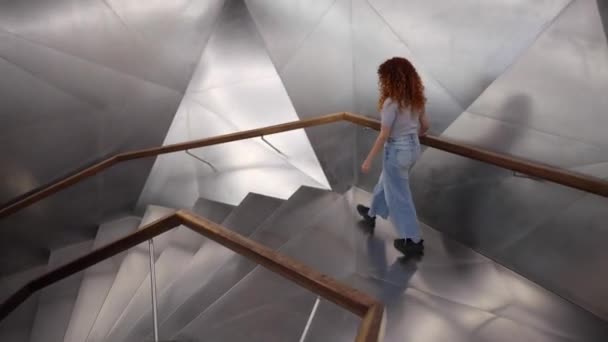 未来的な金属の階段を降りる赤髪の女性 — ストック動画