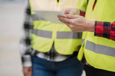 Bir çalışma ortamında dijital tablet, takım çalışması ve teknolojiyi kullanan inşaat işçilerinin ellerinin ayrıntıları.