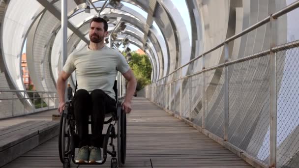 坐在轮椅上的中年男子在时尚的城市桥上显得很有思想 显得很随和 — 图库视频影像