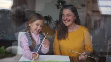 Büyükanne ve torun eğlenceli bir resim seansında gülüşlerini ve yaratıcılıklarını evde paylaşıyorlar..