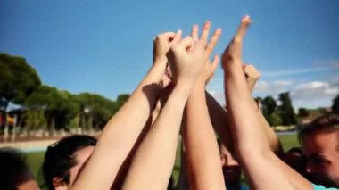 Dişi rugby oyuncuları kutlama ve birlik için ellerini kaldırarak takım ruhunu ve kararlılığını gösteriyor..