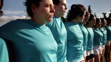 Mavi formalı kararlı bayan rugby oyuncularının bir araya gelip maçtan önce birlik göstermeleri ve odaklanmaları..