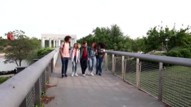 Çeşitli arkadaş grupları gün batımında birlikte bir anın tadını çıkarıyor, gülümsüyor ve dışarıda konuşuyor..