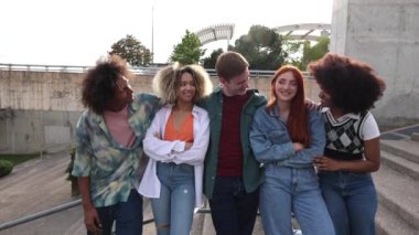 Açık hava parkı ortamında gülümseyen ve kaynaşan, çeşitliliği ve arkadaşlığı kucaklayan çok ırklı Gen Z arkadaş grubu..