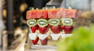 Pazarda karpuz, kivi, çilek ve kavun sergilenen taze meyve şişleri..