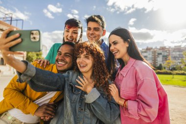 Neşeli, güneşli bir günde selfie çekerken gülümseyen bir grup üniversiteli arkadaş..
