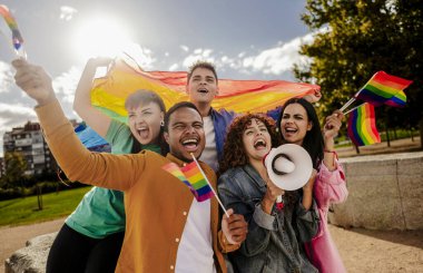 LGBTQ 'yu kutlayan, gökkuşağı bayrakları sallayan ve elinde megafonla gezen bir grup neşeli arkadaş..