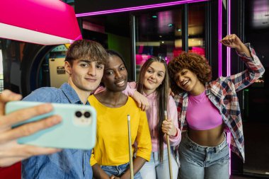 Bir grup gülen arkadaş, bilardo oynadıktan sonra kutlama yaparken selfie çekiyorlar..