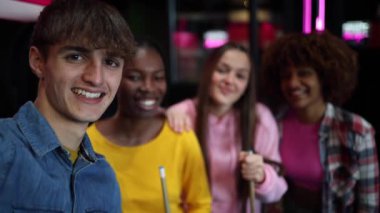 Gülümseyen bir grup genç atari salonunda takılıyor, oyunlardan zevk alıyor ve birlikte eğleniyorlar..