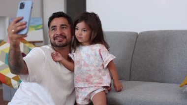 Anne ve oğul birlikte okurken sakin bir anı paylaşıyorlar, oğlu da pencerenin yanındaki rahat sandalyede dinleniyor..