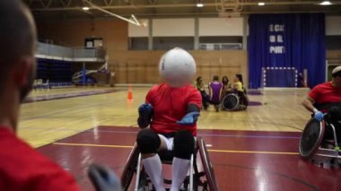 Tekerlekli sandalyedeki basketbolcu bir maçta koçunun tavsiyesini dinliyor.