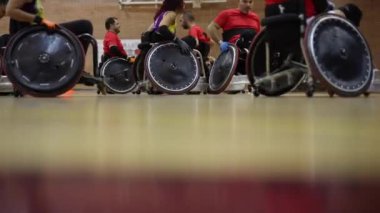 Tekerlekli sandalye ragbi maçının başlamasını bekleyen sporcular ellerinden geleni yapmaya hazırlar.