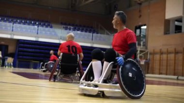 Tekerlekli sandalye kullanan sporcular basketbol maçından önce pratik yapıyorlar.