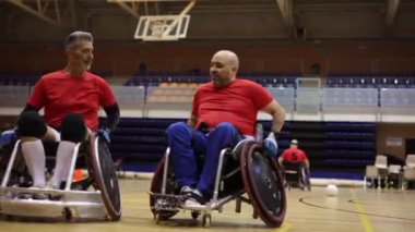 Tekerlekli sandalyedeki basketbol oyuncuları spor salonunda antrenman yapıyor ve hazırlanıyorlar.