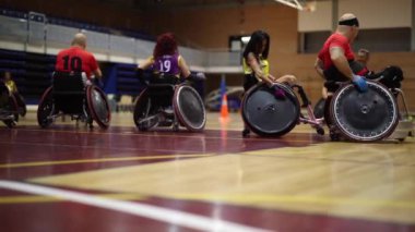 Tekerlekli sandalye basketbol takımı sahada antrenman yapıyor. Maç için hazırlanıyor.