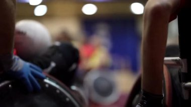 Tekerlekli sandalyedeki basketbol oyuncuları maçtan önce sahada ısınıyor.