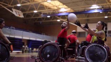 Tekerlekli sandalyedeki ragbi oyuncuları spor salonundaki yarışmadan önce oyun taktikleri üzerinde çalışıyorlar.