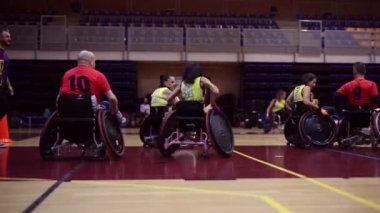 Tekerlekli sandalyedeki basketbol oyuncuları bir oyun sırasında sahada hareket ediyorlar