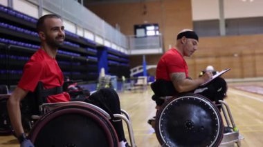 Tekerlekli sandalye spor takımı antrenörü takım çalışmasını izlerken not alıyor.