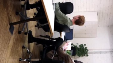 Çok ırklı girişimciler yeni bir proje hakkında verimli bir tartışmaya giriştiler. Bir iş kadını, iş arkadaşlarına işbirliği ve fikir paylaşımını teşvik eden bir belge sunar.