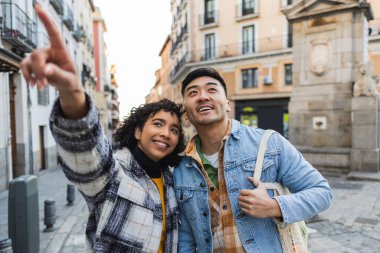 Sevgililer Günü 'nde Madrid' i gezen çok kültürlü genç çift. Sokakta yürürken ilginç bir şeye işaret eden kadın.
