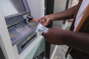 Bir adamın bankamatikten 20 ve 50 escudo banknot çekmesini yakından görmek Portekiz 'in hareketli ekonomisindeki finansal işlemleri gösteriyor.