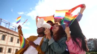 Coşkulu genç aktivistler, gökkuşağı bayrakları taşıyan ve eşitlik ve kapsama mesajlarını halka açık bir alana yaymak için megafon kullanan lgbtq artı hakları için gösteri yapıyorlar.