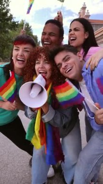 Dört mutlu genç aktivist ellerinde gökkuşağı bayrakları ve megafonlarla bağırıyorlar, lgbtq artı hak ve eşitlik için kutlama ve protesto yapıyorlar.