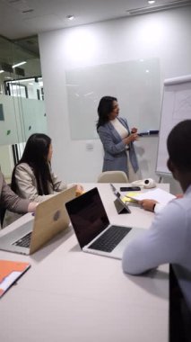 Deneyimli iş kadını, çeşitli meslektaşlarıyla verimli bir toplantı yaparak, modern ofis ortamında işbirliğini ve yeniliği teşvik ediyor.