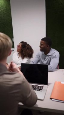 Modern bir çalışma alanında verimli bir toplantı sırasında bir proje üzerinde işbirliği yapan, tartışmalara katılan ve stratejiler geliştiren çok ırklı iş adamları.