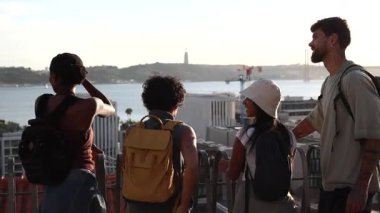 Üç turist Lizbon 'un şehir manzarasının panoramik manzarasının tadını çıkarıyorlar. Güneşli bir günde miradouro da senhora do monte perspektifinden tagus nehri ve cristo rei heykelleri sunuyorlar.