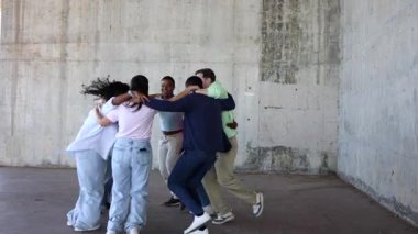 Mutlu çok ırklı lgbt dostları dans ediyor, sarılıyor ve birlikte gülüyorlar. Arkadaşlıklarını ve çeşitliliklerini beton şehir ortamında kutluyorlar.