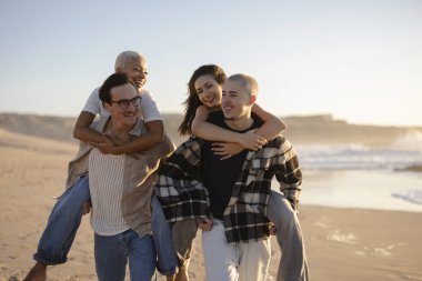 İki adam gün batımında muhteşem bir plajda sevgililerini sırtında taşıyor. Neşeli ve kaygısız bir atmosfer yaratıyor.