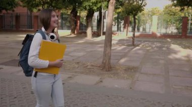 Okul binası dışında sıcak kucaklaşmayı paylaşan kız öğrenciler, okul tatilinde gerçek dostluk ve duygusal bağlarını dile getiriyorlar.