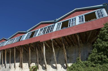 Traditional architecture with wooden and stone walls and balcony of monastery named st. George at lake Doxa in Corinth, Greece