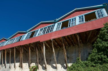 Traditional architecture with wooden and stone walls and balcony of monastery named st. George at lake Doxa in Corinth, Greece