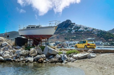 Yunanistan 'ın Skyros adasının limanında yelkenli ve sarı bir araba tamir ediliyor.