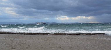 Marikes plajının panoramik manzarası ve kışın Yunanistan 'da bir feribot.