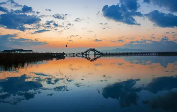 Sabahın erken saatlerinde gölün etrafında yürüyorum ve güneşin doğuşunu görüyorum.