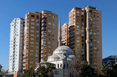 A dome mosque with two minarets is among the high apartments
