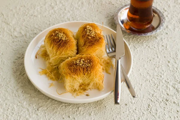 传统的土耳其脆皮甜点杯卡达伊夫白盘与餐具和茶 — 图库照片