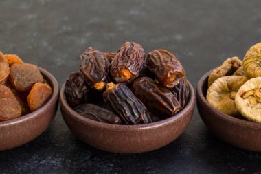 Lüks kurutulmuş meyve, siyah yüzeydeki ahşap kasede tasarlandı. Ramazan kavramı.