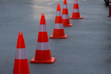 Kırmızı koniler asfalt yolu ikiye böler, trafik dikkatlice kesişir.