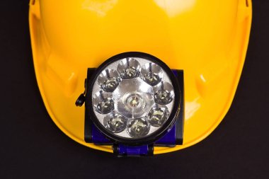 Sarı renkli işçi şapkası siyah arka planda, üstten ışık, ön görüş