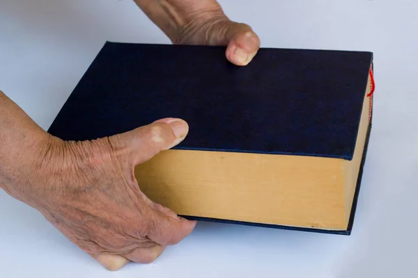 Старая Рука Держит Старую Толстую Книгу Белой Поверхности — стоковое фото