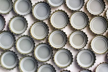 Beyaz yüzeyde tasarlanmış cam şişe soda metal kapaklarının iç tarafı.