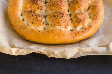Geleneksel Türk Ramazan Ekmeği ve siyah yüzey üzerine fırın kağıdı 