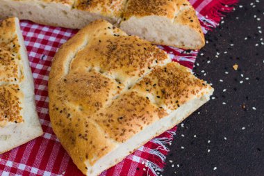 Dilimlenmiş geleneksel Ramazan Ekmeği Pita, kırmızı kareli peçeteye dizayn edilmiş.