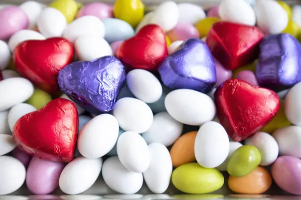 五彩缤纷的杏仁糖果是用心形包裹的巧克力设计的 免版税图库照片