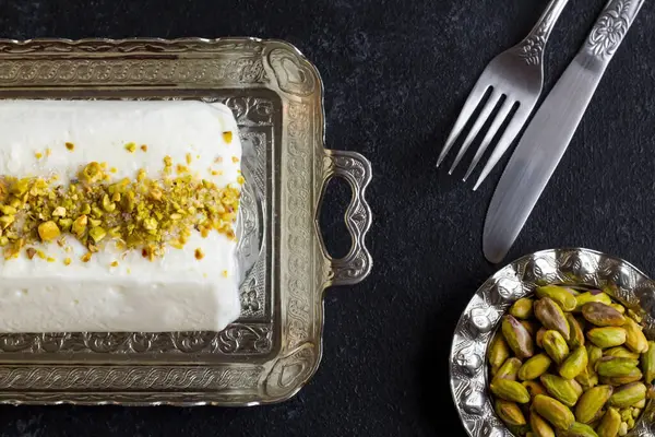 传统土耳其玛拉丝切冰奶油 银盘上有餐具和开心果 免版税图库图片
